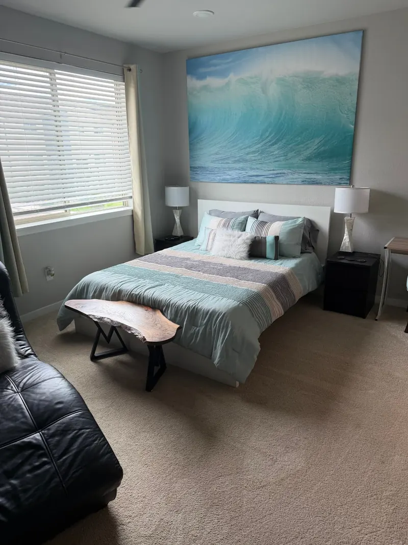 The same bedroom after cleaning, with the bed made